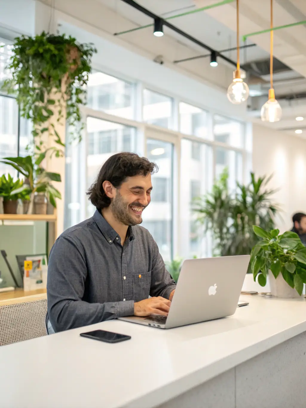 A person using a well-organized coworking space management template on a laptop, smiling confidently, with a bright and modern coworking environment in the background.